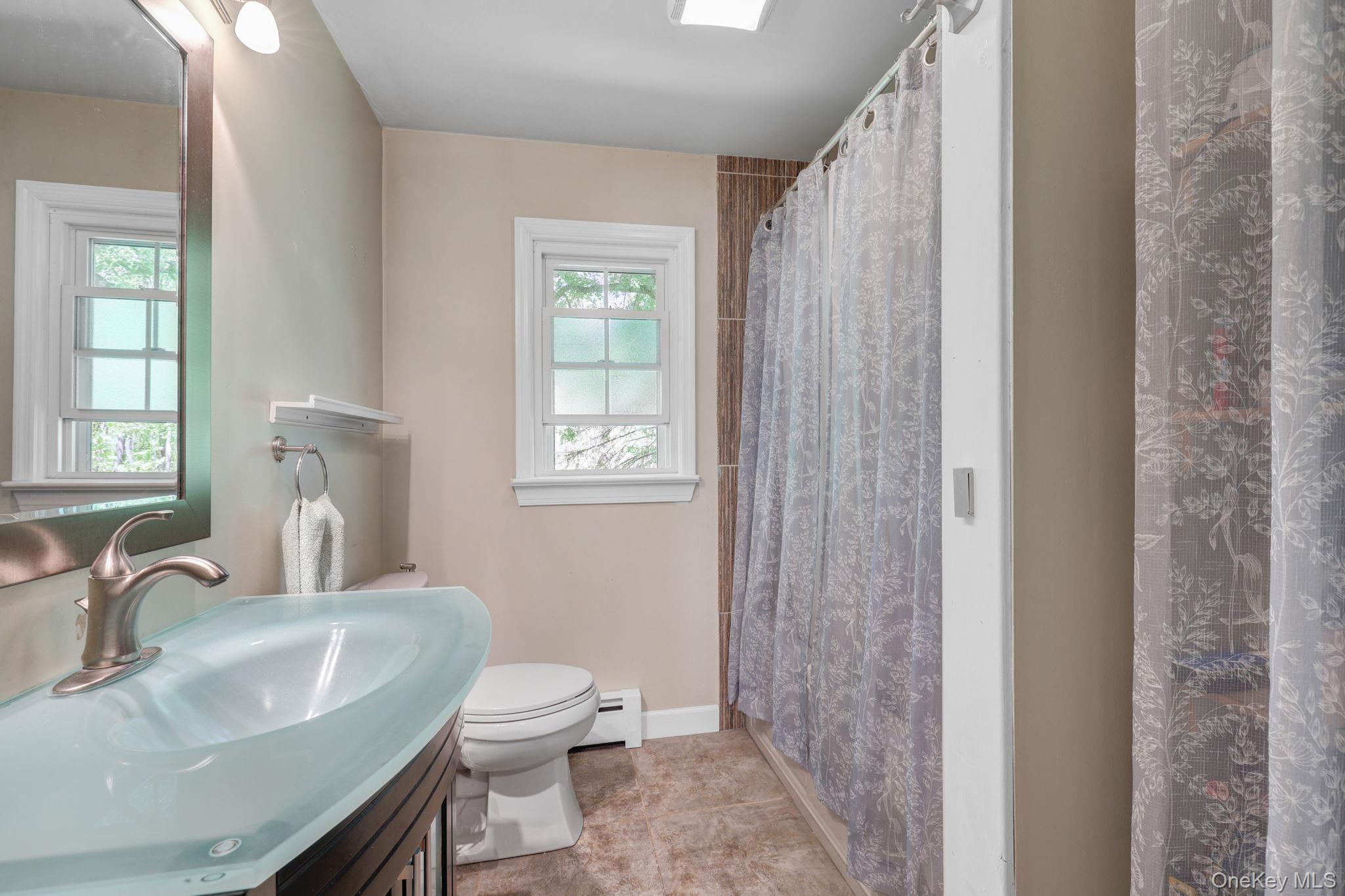 94 Smithtown Road Fishkill, NY 12524 - Photo 27 of 45 a bathroom with a sink a toilet and a window