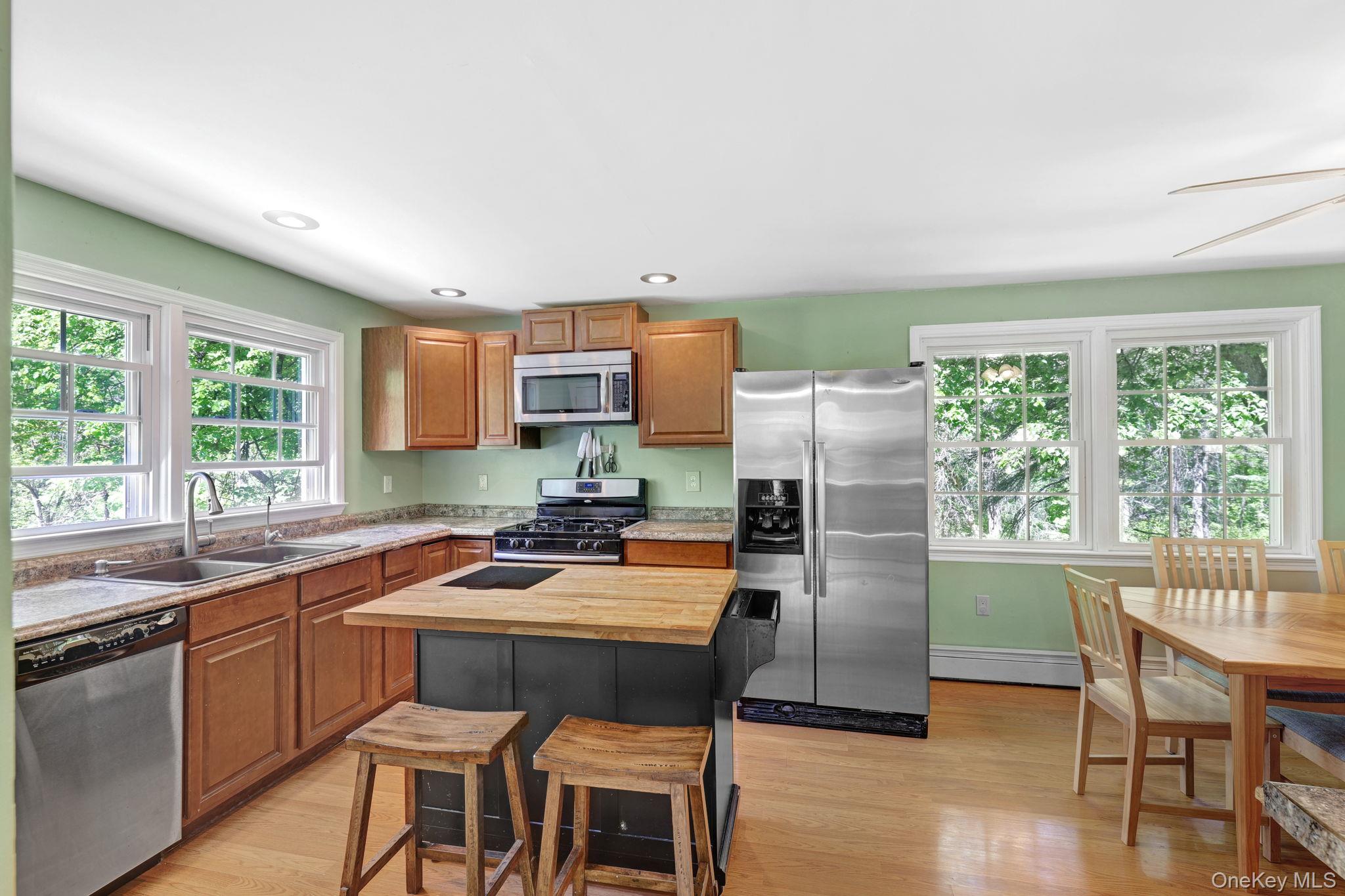 94 Smithtown Road Fishkill, NY 12524 - Photo 32 of 45 a kitchen with a table chairs refrigerator and microwave