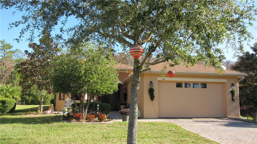 241 Scripps Ranch Road Kissimmee, FL 34759 - Photo 1 of 1 a view of a white house next to a yard with big trees