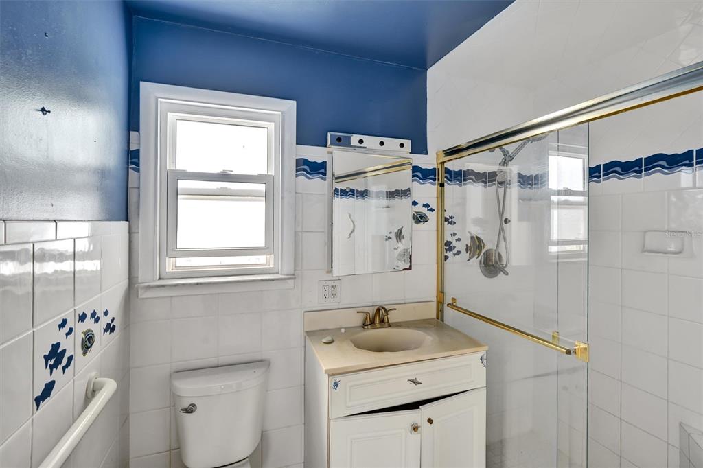 135 143rd Avenue Madeira Beach, FL 33708 - Photo 12 of 20 a bathroom with a granite countertop sink toilet and shower