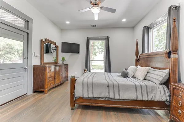 a bedroom with a bed and a flat tv screen on dresser