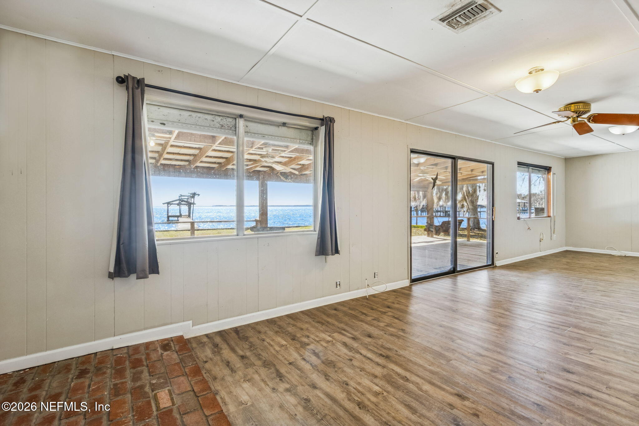 8528 Moody Canal Road St. Augustine, FL 32092 - Photo 13 of 61 an empty room with wooden floor and windows