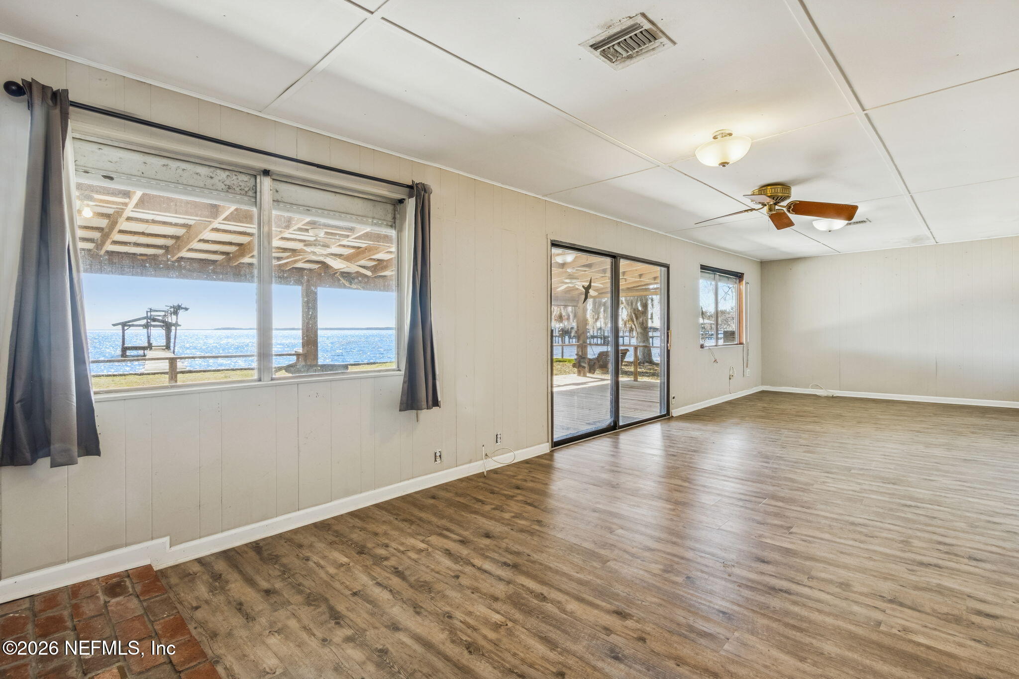 8528 Moody Canal Road St. Augustine, FL 32092 - Photo 14 of 61 a view of an empty room with wooden floor and a window