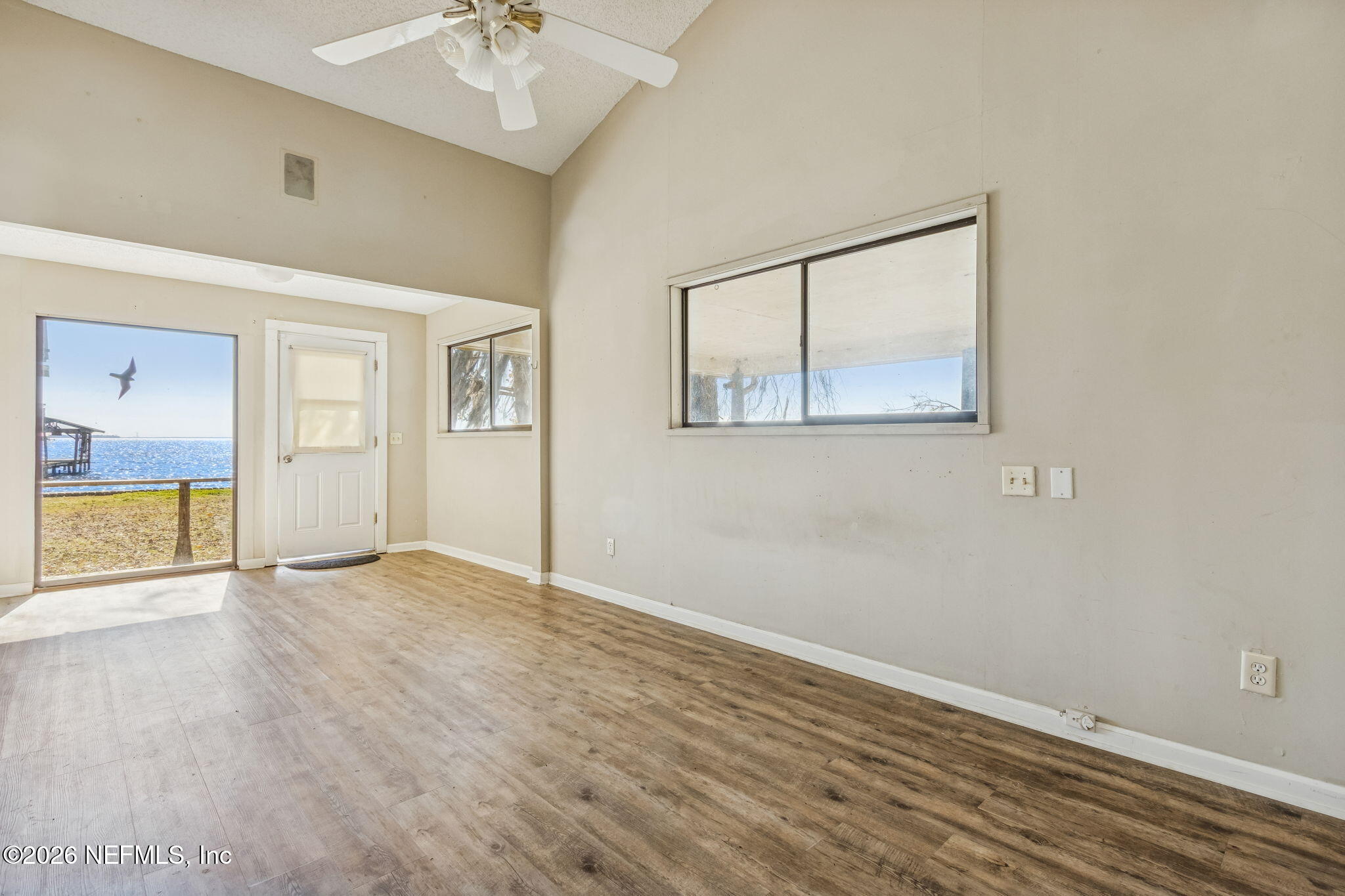 8528 Moody Canal Road St. Augustine, FL 32092 - Photo 18 of 61 an empty room with wooden floor and windows