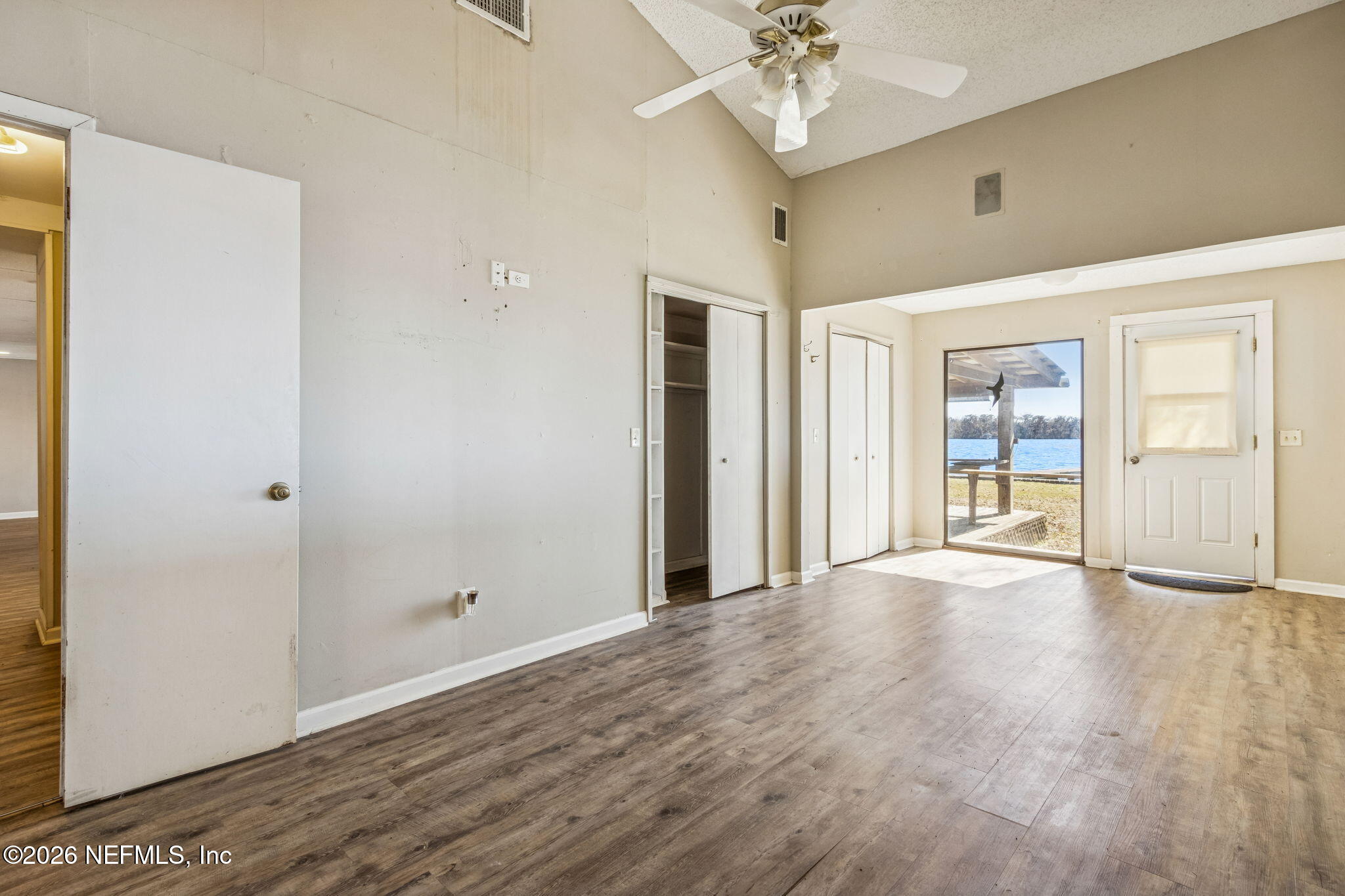8528 Moody Canal Road St. Augustine, FL 32092 - Photo 19 of 61 an empty room with wooden floor and windows