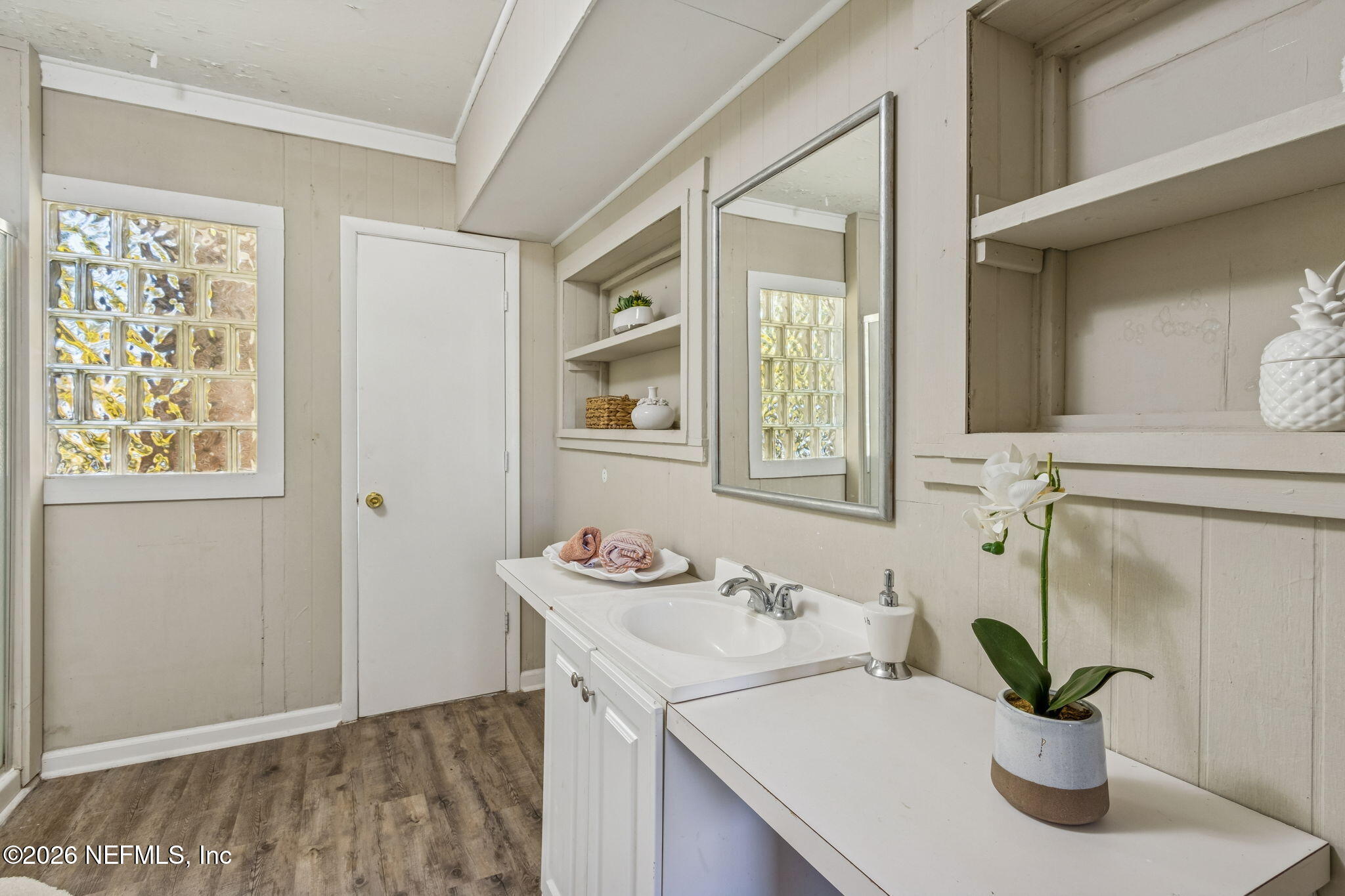 8528 Moody Canal Road St. Augustine, FL 32092 - Photo 27 of 61 a bathroom with a sink a mirror and a potted plant