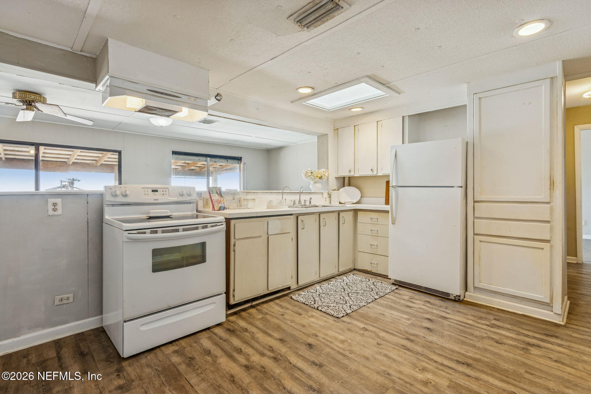 8528 Moody Canal Road St. Augustine, FL 32092 - Photo 8 of 61 a kitchen with a sink a stove a refrigerator and white cabinets