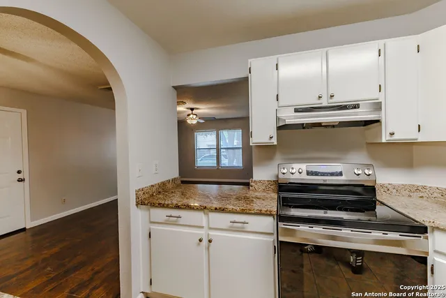 a kitchen with kitchen island granite countertop a stove and a sink