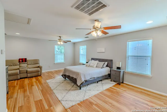 a spacious bedroom with a bed and a chandelier