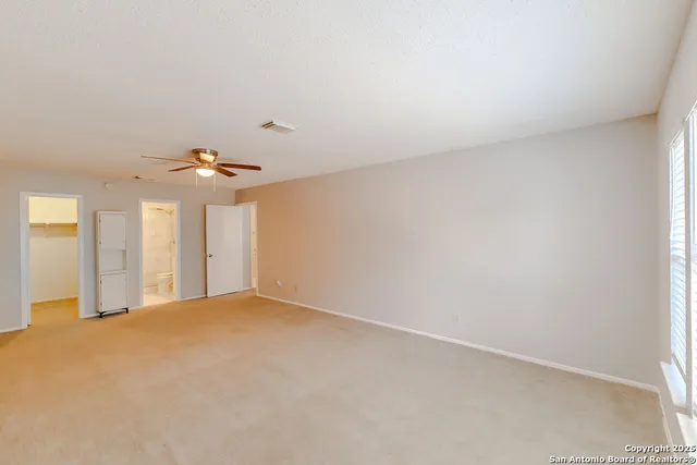 an empty room with chandelier fan