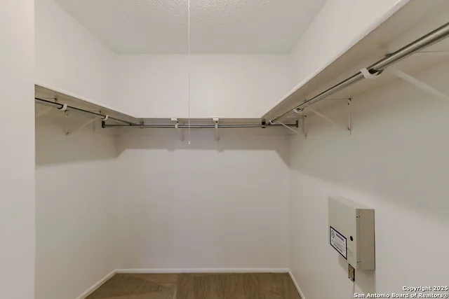 a view of walk in closet with empty racks
