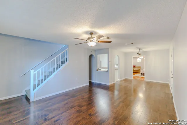 a view of a livingroom with wooden floor and a ceiling fan