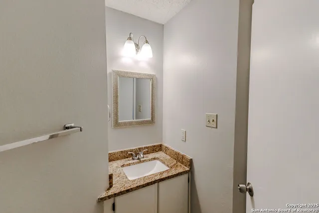a bathroom with a sink vanity and mirror