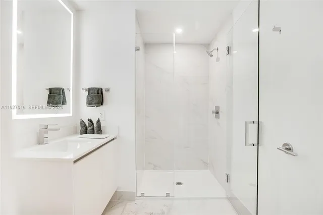 a bathroom with a shower sink vanity and mirror