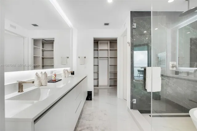 a bathroom with a double vanity sink mirror and shower