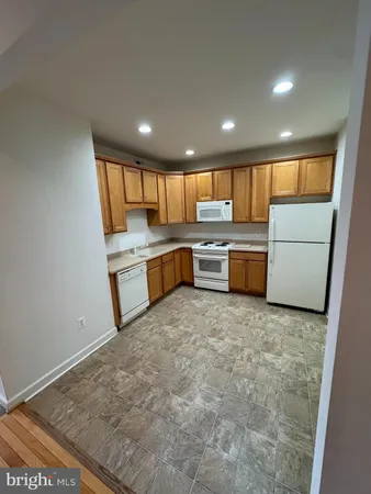 a kitchen with kitchen island a large counter top stainless steel appliances and a window