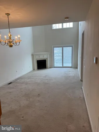 a view of an empty room with a fireplace and a window