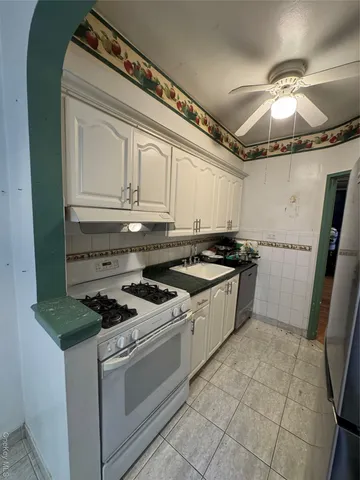 a kitchen with granite countertop a stove sink and cabinets