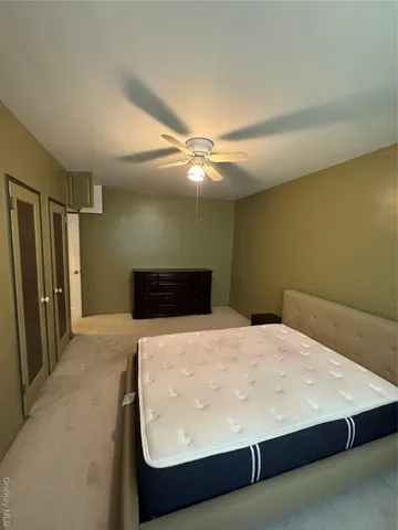 a bedroom with a bed and a ceiling fan