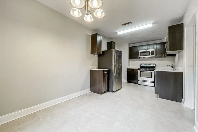 a kitchen with stainless steel appliances granite countertop a refrigerator and a stove top oven