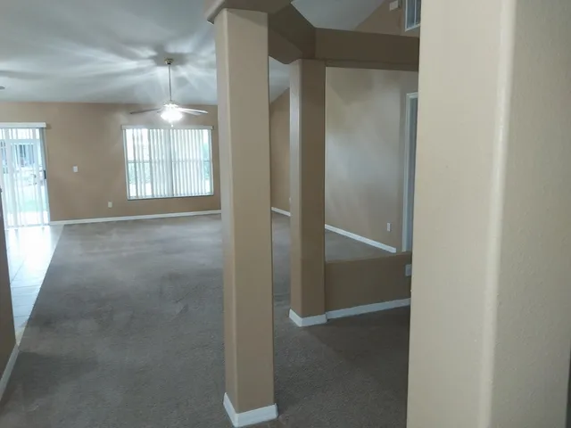 a view of an empty room with window and wooden floor