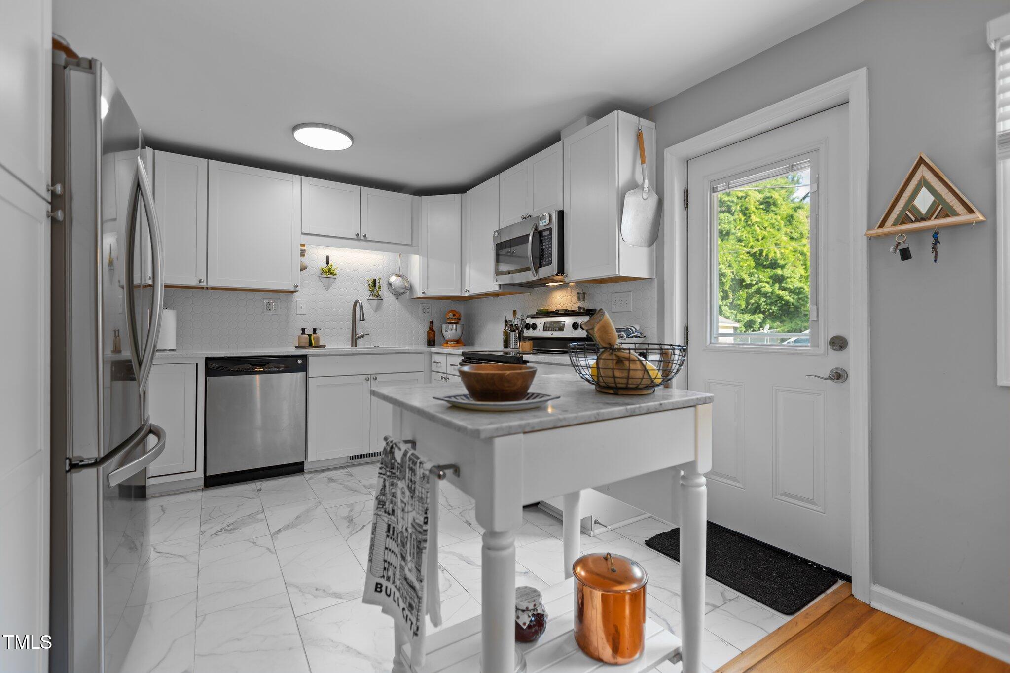 a kitchen with stainless steel appliances a stove a refrigerator and a sink
