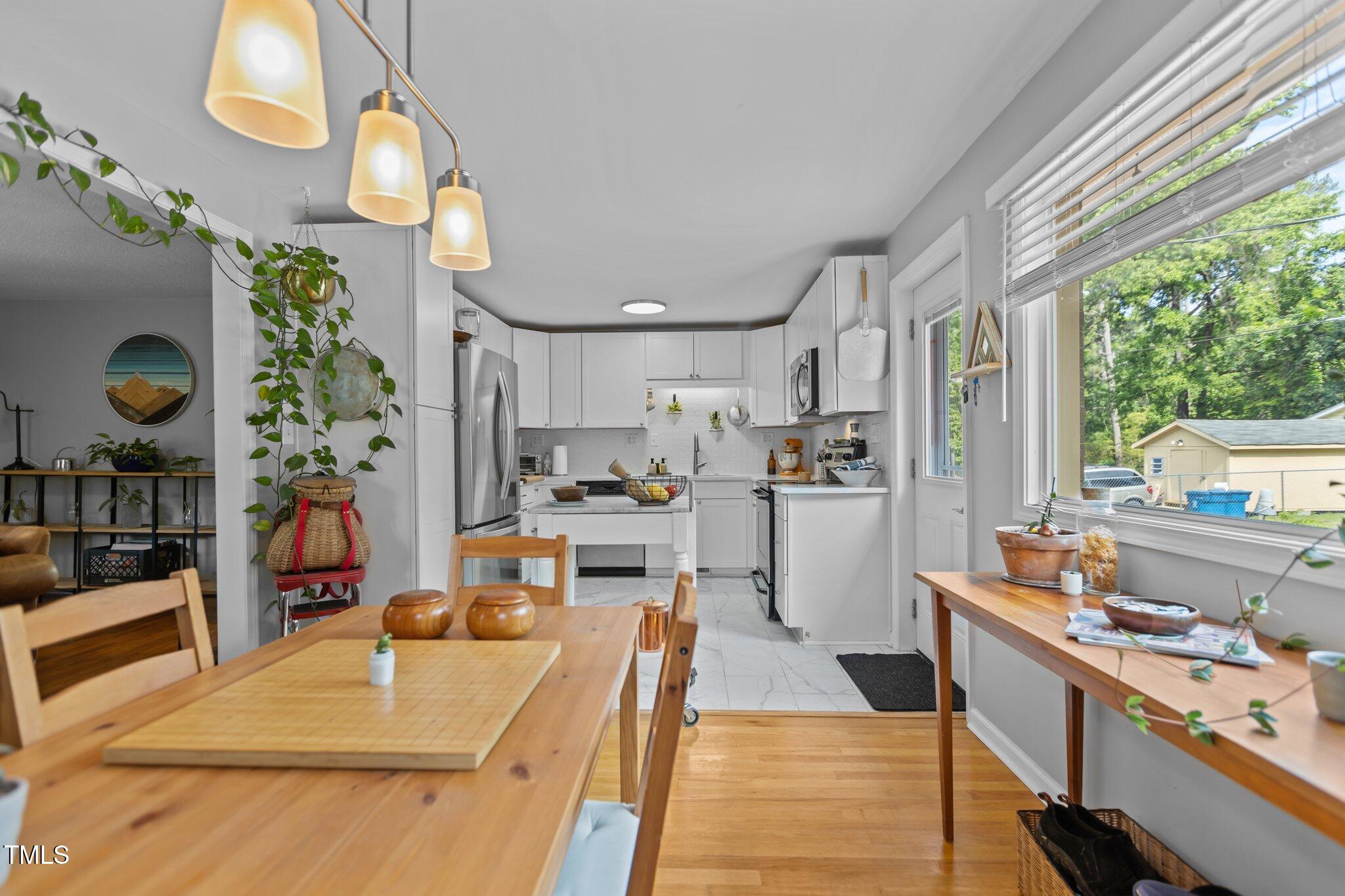 2125 Cheek Road Durham, NC 27704 - Photo 11 of 32 a room with stainless steel appliances kitchen island granite countertop lots of counter top space and wooden floor