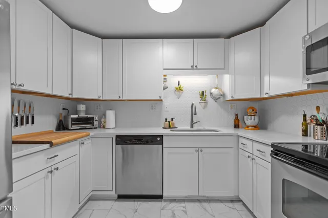 a kitchen with white cabinets sink and appliances
