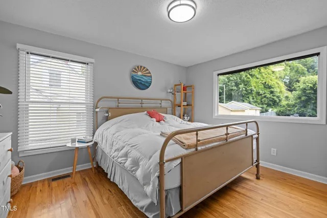 a bed sitting in a bedroom next to a window