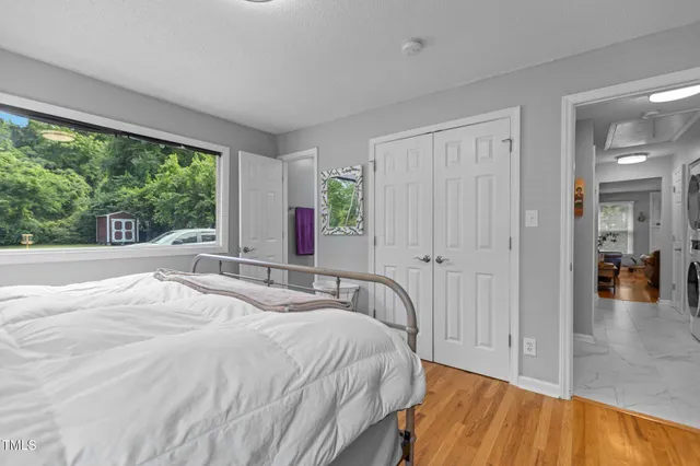 a spacious bedroom with a bed and a large window