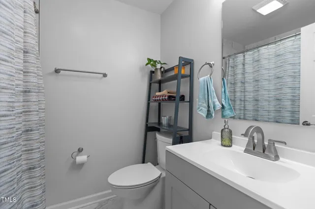a bathroom with a sink vanity mirror and toilet