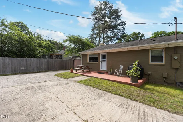 a view of a house with backyard and sitting area