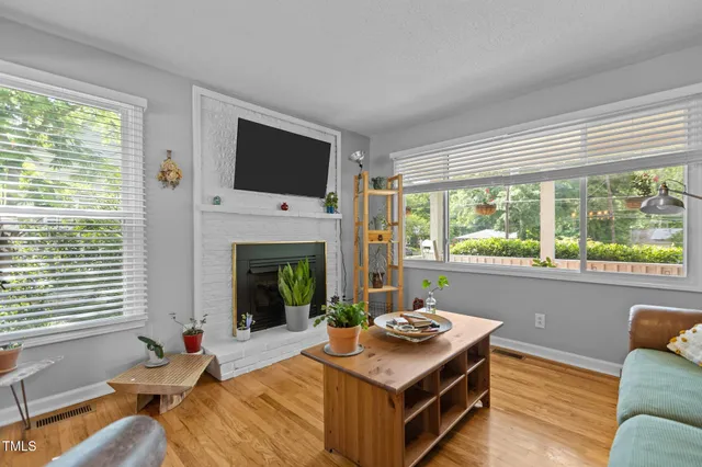 a living room with furniture a flat screen tv and a fireplace