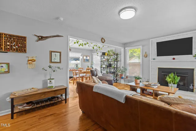 a living room with furniture a flat screen tv and a fireplace