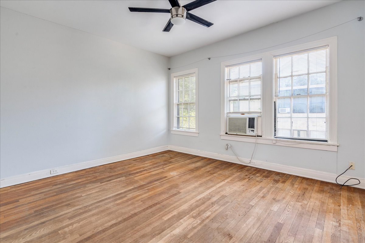1916 Robbins Place Austin, TX 78705 - Photo 12 of 21 an empty room with wooden floor fan and windows