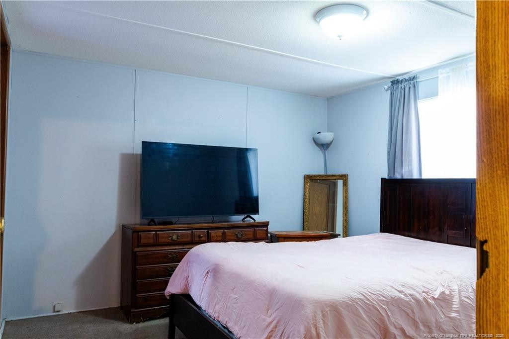 231 Knight Lane Autryville, NC 28318 - Photo 20 of 27 a bedroom with a bed and a flat screen tv