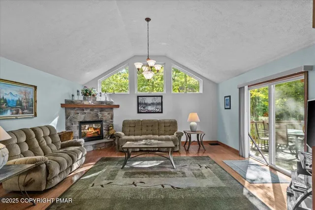 a living room with furniture a fireplace and a large window