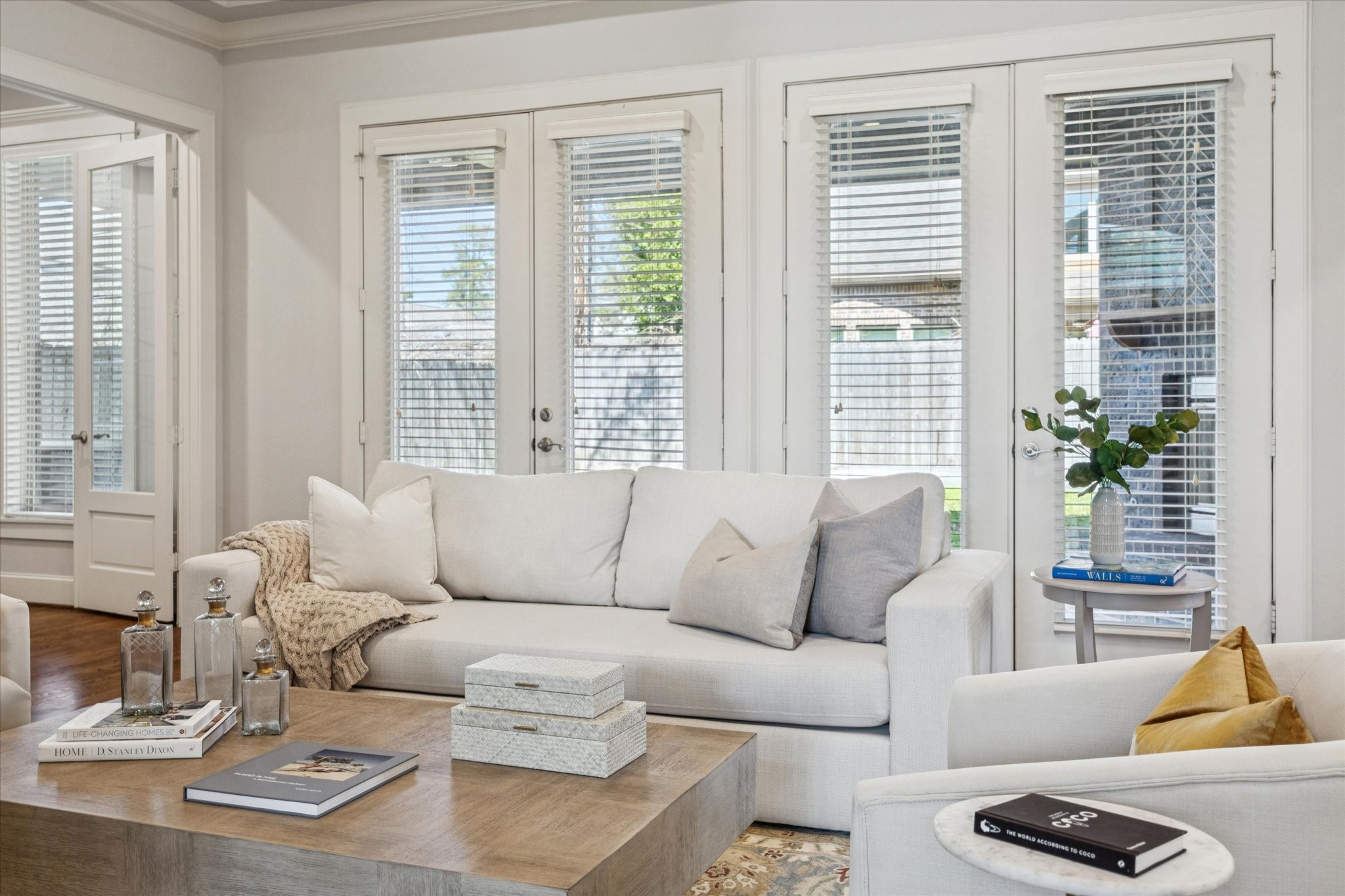 Living room with expansive windows, offering a bright, airy feel and beautiful views of the backyard.