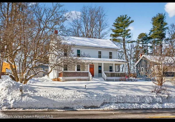 a front view of residential houses with yard and trees