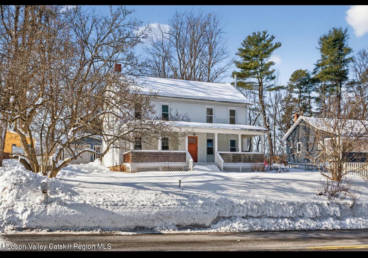 a front view of residential houses with yard and trees