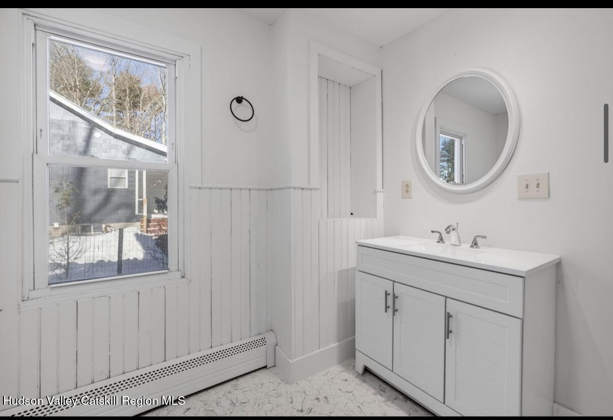 919 Elting Road Rosendale, NY 12472 - Photo 12 of 28 a bathroom with a toilet a sink a mirror and a window