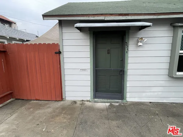 a side view of a house with a wooden fence