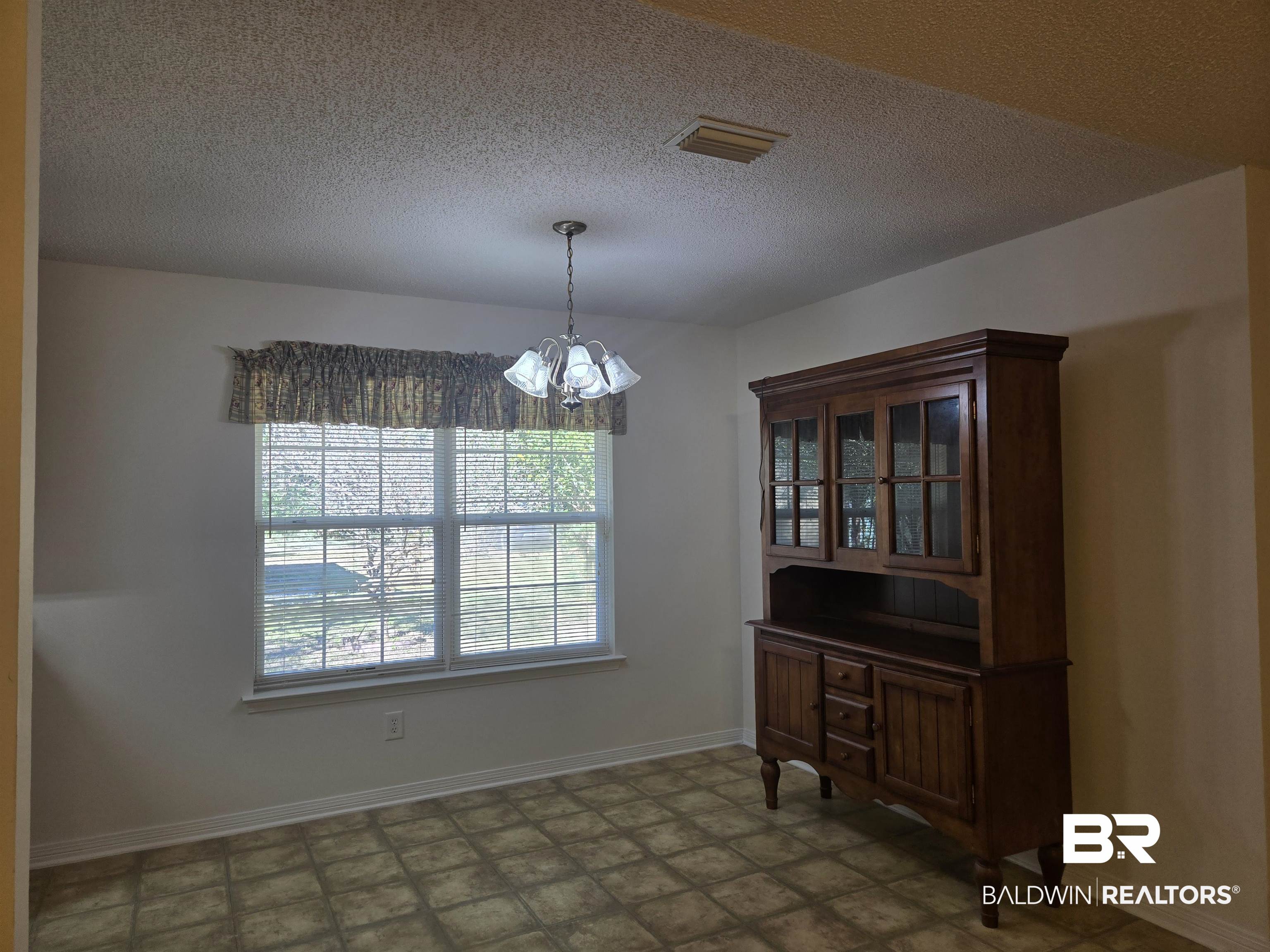 2554 Riverside Drive Mobile, AL 36605 - Photo 13 of 43 Unfurnished dining area featuring a chandelier and a textured ceiling