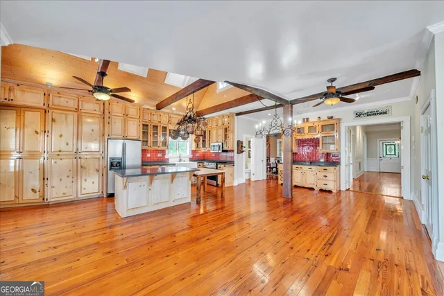 a kitchen with stainless steel appliances granite countertop a sink a stove and a wooden floors