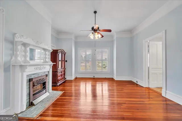 a view of an empty room with a ceiling fan and window