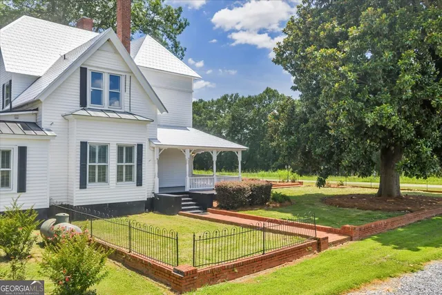 a front view of house with a garden and trees