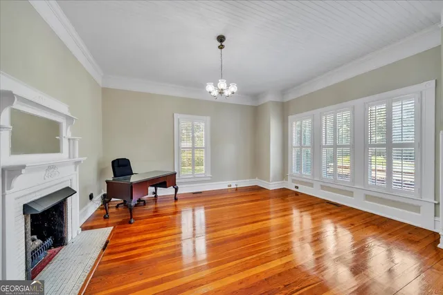 a view of an empty room with window and wooden floor