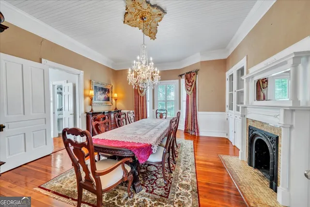 a view of a dining room with furniture a chandelier and wooden floor