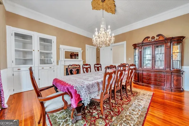a view of a dining room with furniture a chandelier and wooden floor