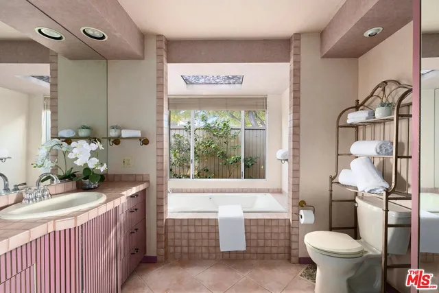a bathroom with a double vanity sink toilet and a mirror